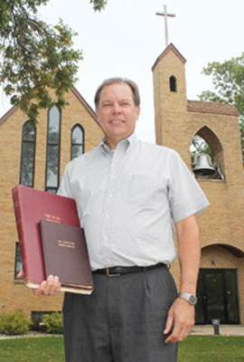 Pastor Thomas Queck holds the original record book of every birth, baptism, confirmation, wedding and funeral ever held at Zion Evangelical Lutheran Church in Annandale. The black book is the churchï¿½s constitution, which is written in German. The bell in the church tower is the Zionï¿½s original bell, which was imported from Germany in 1908. Zion is celebrating its 125th anniversary on Sunday, Sept. 29, and Queck is marking 25 years at the church.
